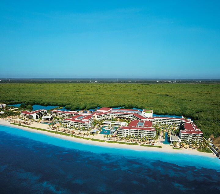 Aerial view of Secrets Riviera Cancun tucked between the Caribbean sea and the lagoon at Bahía Petempich.