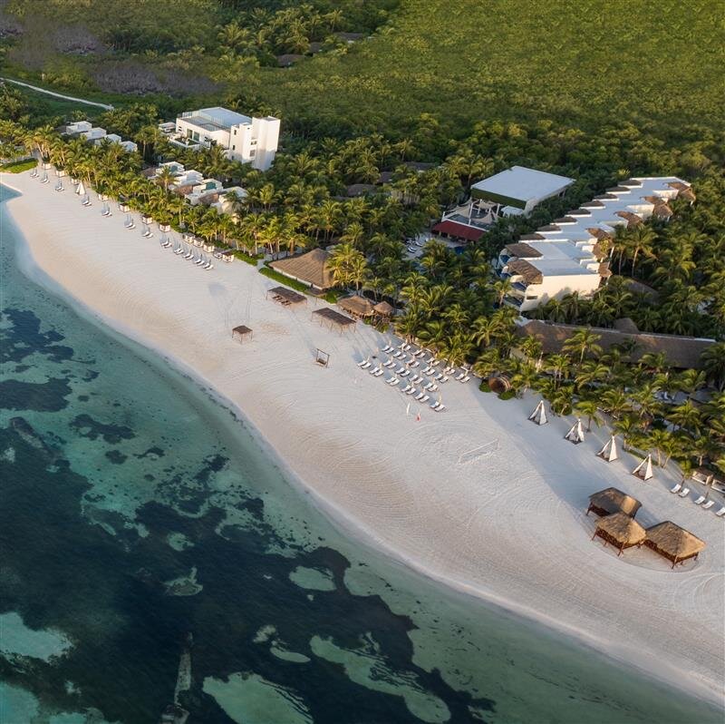 Vista aérea de El Dorado Maroma en Riviera Maya, hotel boutique frente a una de las playas más reconocidas del mar Caribe, playa Maroma, con vegetación tropical y ambiente exclusivo.